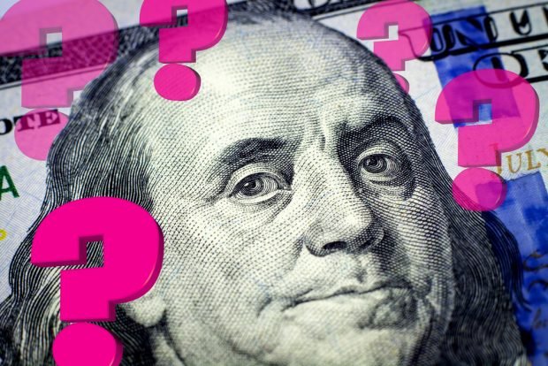 Questions remain about the economic outlook visualized with question marks on top of a $100 bill..