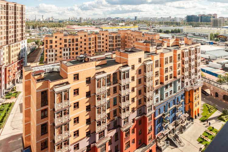 Cityscape of house building exterior mixed-use urban multi-family residential district area development sunny day