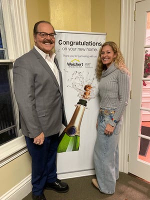 Realtor Tony Verna congratulates Kim Eagle after settlement on a new house in Wrightstown she and her husband bought in Wrightstown after moving from Texas to Bucks County last week.